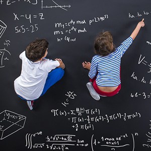 kids pointing at math equations on a chalkboard