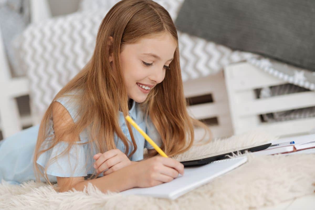 girl smiling with writing in a notebook