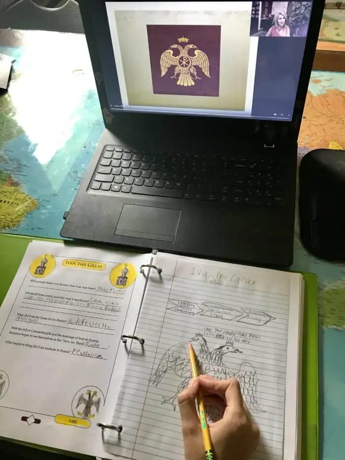 The Mystery of History workbook pages with laptop open for a video lecture