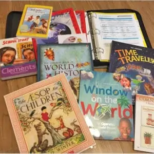 various children\'s books and a binder open, all spread out on the floor
