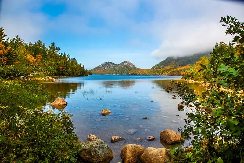 Early morning panoramic view of the fog, water and autumn colors of Long Pond in Acadia National Park