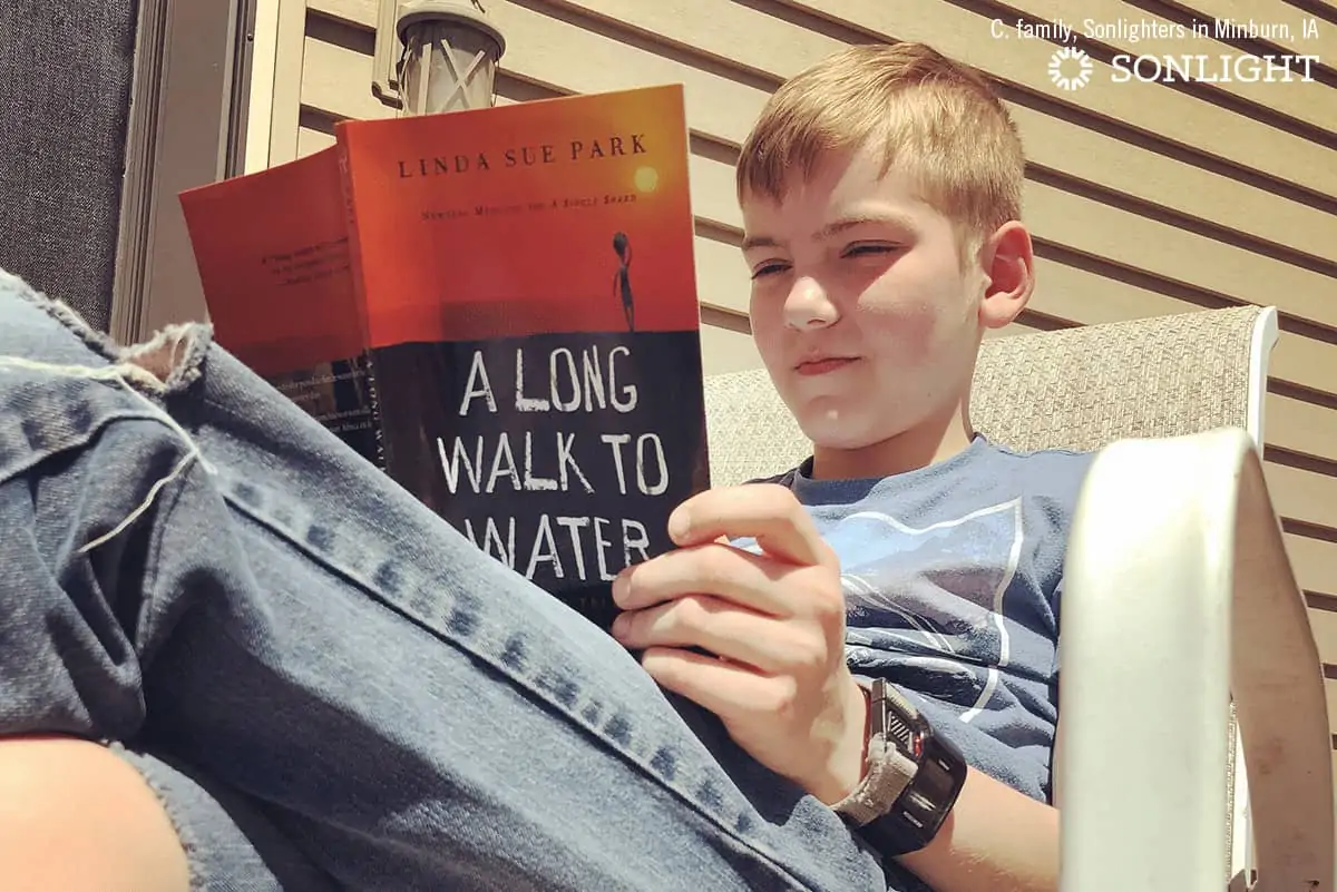 a boy sitting down reading a book