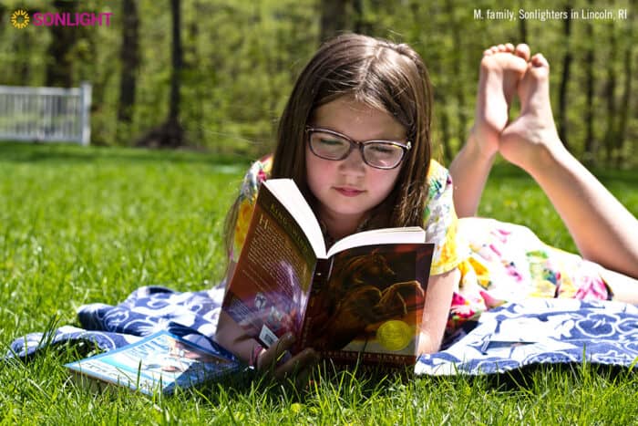 girl reads a novel lying on the grass