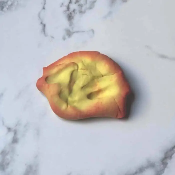 gold and red color changing playdough on a counter.